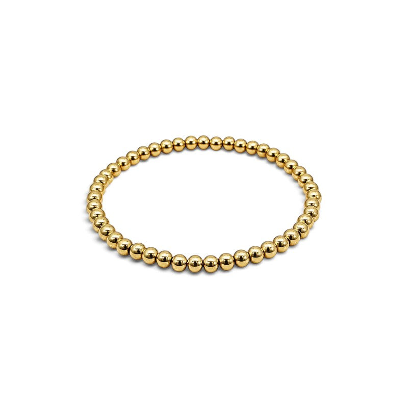 Pulsera elástica de bolitas de 3 mm en goldfilled de la marca ClaraJoyas, diseño minimalista y brillante.