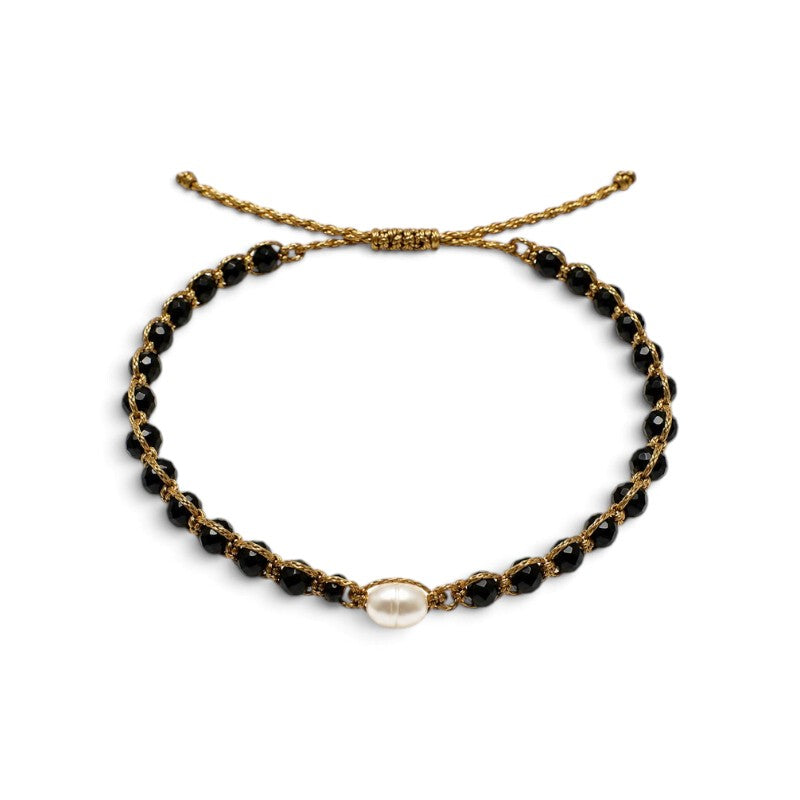 Pulsera ajustable ClaraJoyas con hilo dorado, cuentas de ónix negro y una perla central blanca