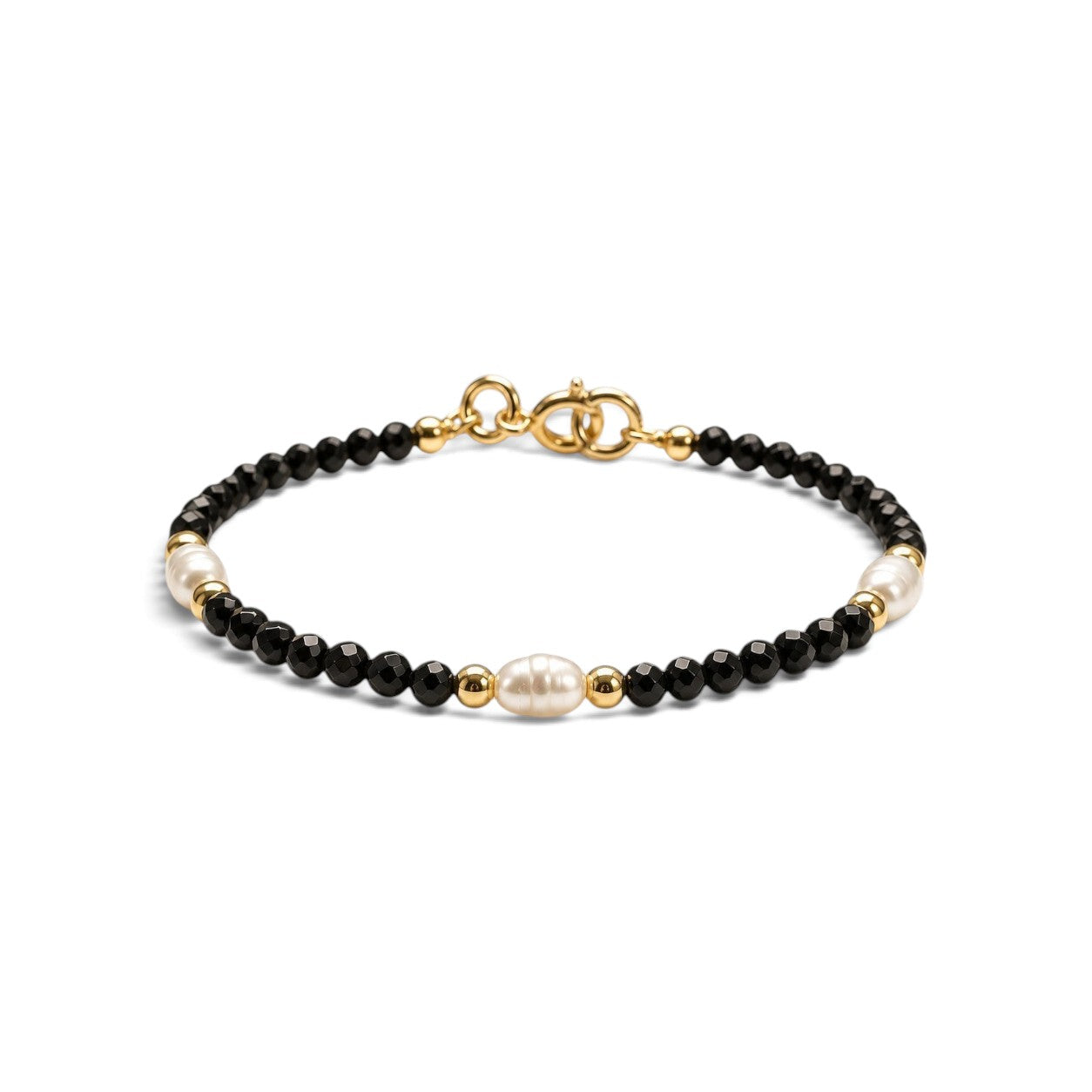 Pulsera ClaraJoyas de cuentas de onix negro facetado con tres perlas blancas y detalles dorados, ajustable de 16 cm.