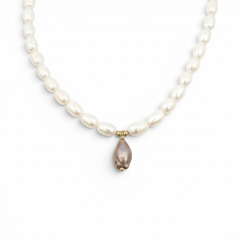 ClaraJoyas white oval pearl necklace with a single pink baroque pearl pendant and gold accents.